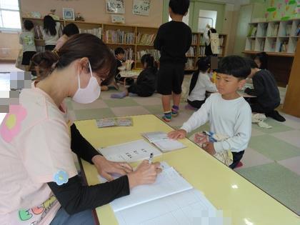 貸し出しコーナーで絵本を借りています。