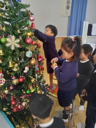 クリスマスツリーに飾りつけをしています。
