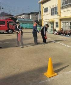 先生たちが対象物にむけて消火器を使って消火訓練をしています。