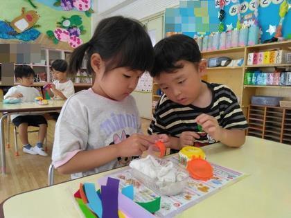 わつなぎの作り方を年ちゅじが年少児に教えています。
