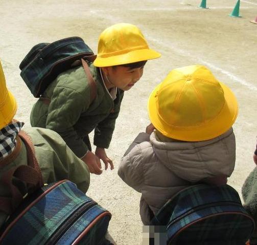 年長児が年少児にやさしく声をかけています