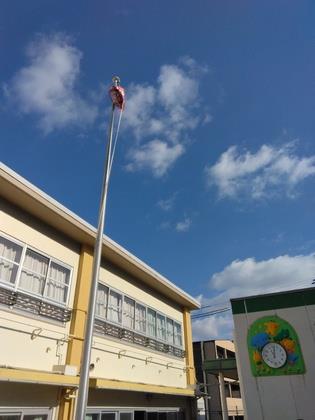 みんなで旗ポールに袋を吊るそうと考えてロープに括り付け準備しています。