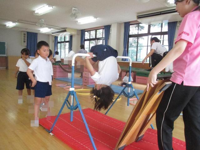 ロイター板を蹴り上げて鉄棒の逆上がりに挑戦しています。