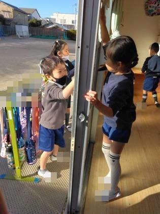 窓のさんを拭いています。