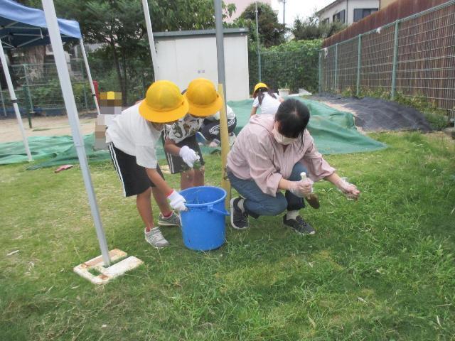 保護者と園児で力を出して草抜きをしています。