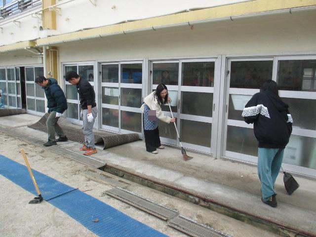 テラスのマットをめくって掃き掃除をしています。