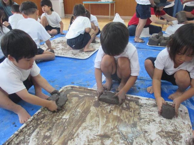 土粘土が乾燥しないように、四角く形を整えています。