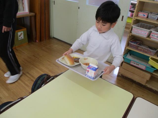 トレイをしっかりと持って自分の席まで給食を運んでいます。