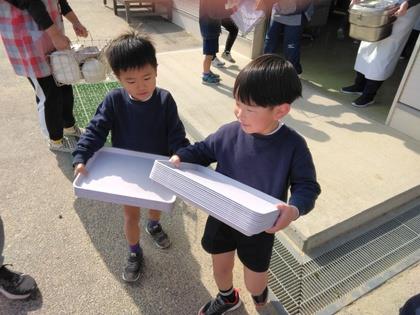 給食室から食器を運んでいます。