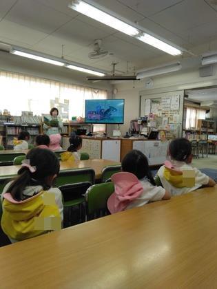 大画面に映った絵本を読んでもらっている