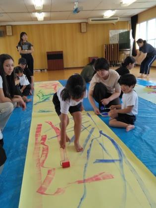 ローラーを使って絵具遊びをしている