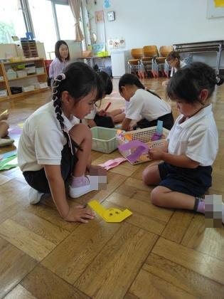 年長が年少に遊び方を教えている