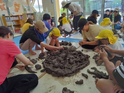 大きなピザをグループで作っている