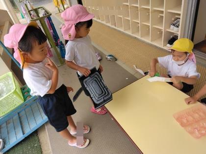 年長児が年少児に船を作っている