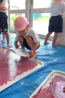 トレイに描いた絵を紙に写している