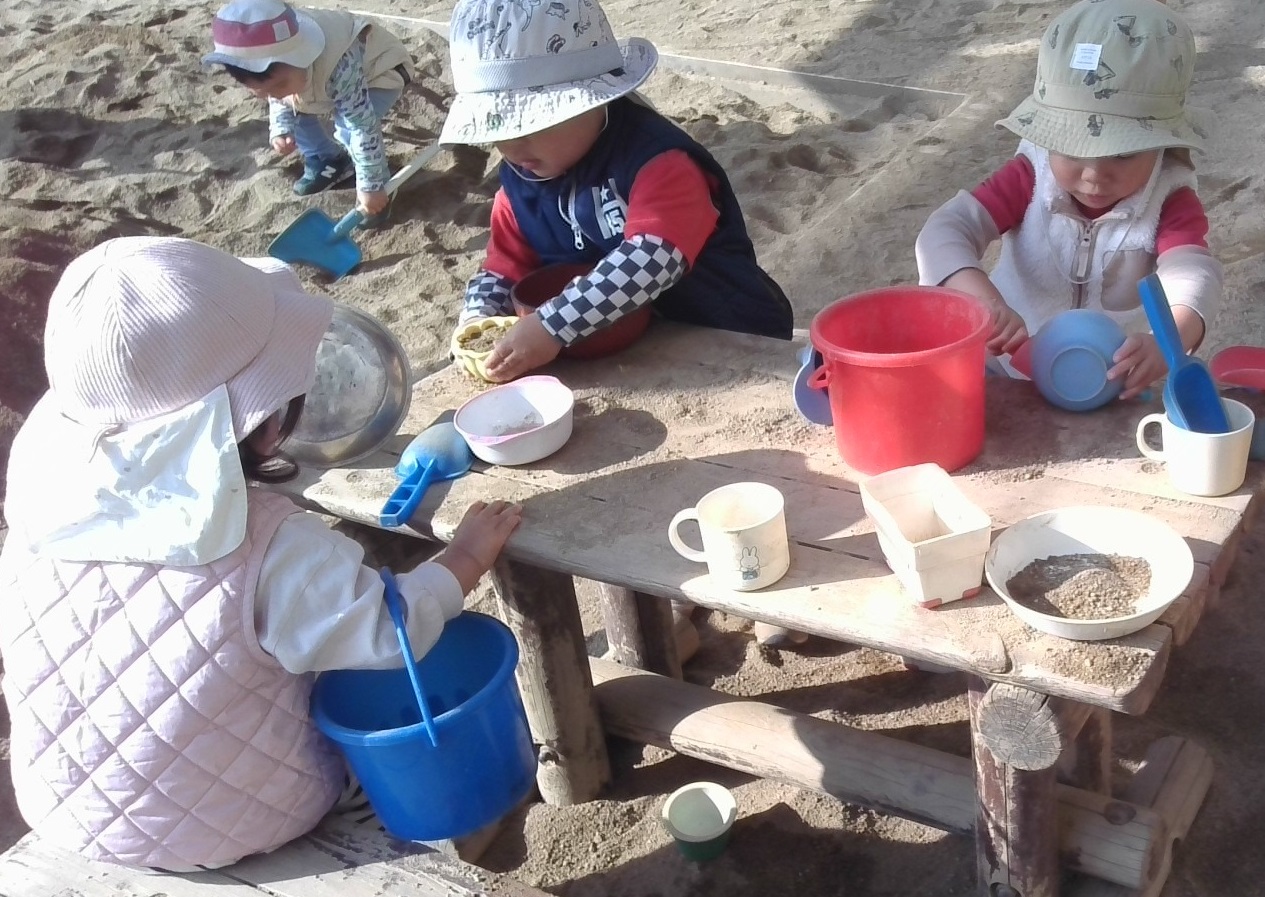 砂遊びをする1歳児