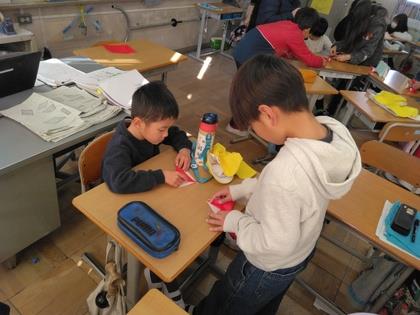 5年生に折り紙を教えてもらう子ども