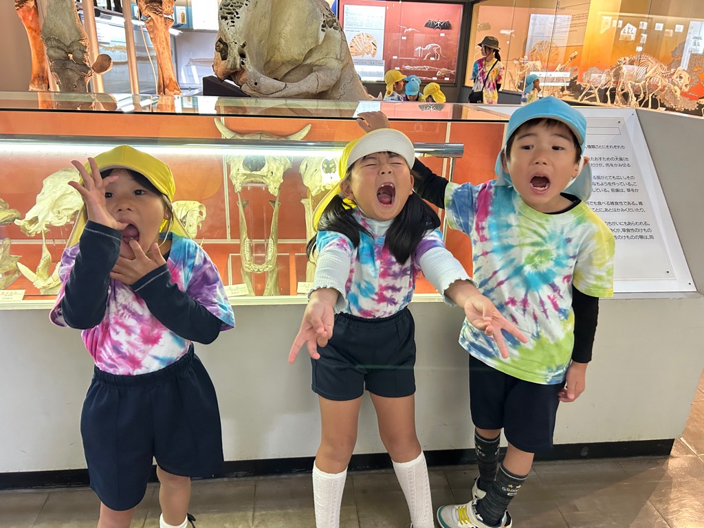 色々な動物のあごの骨を見ながら口を大きく開けて比べる子ども